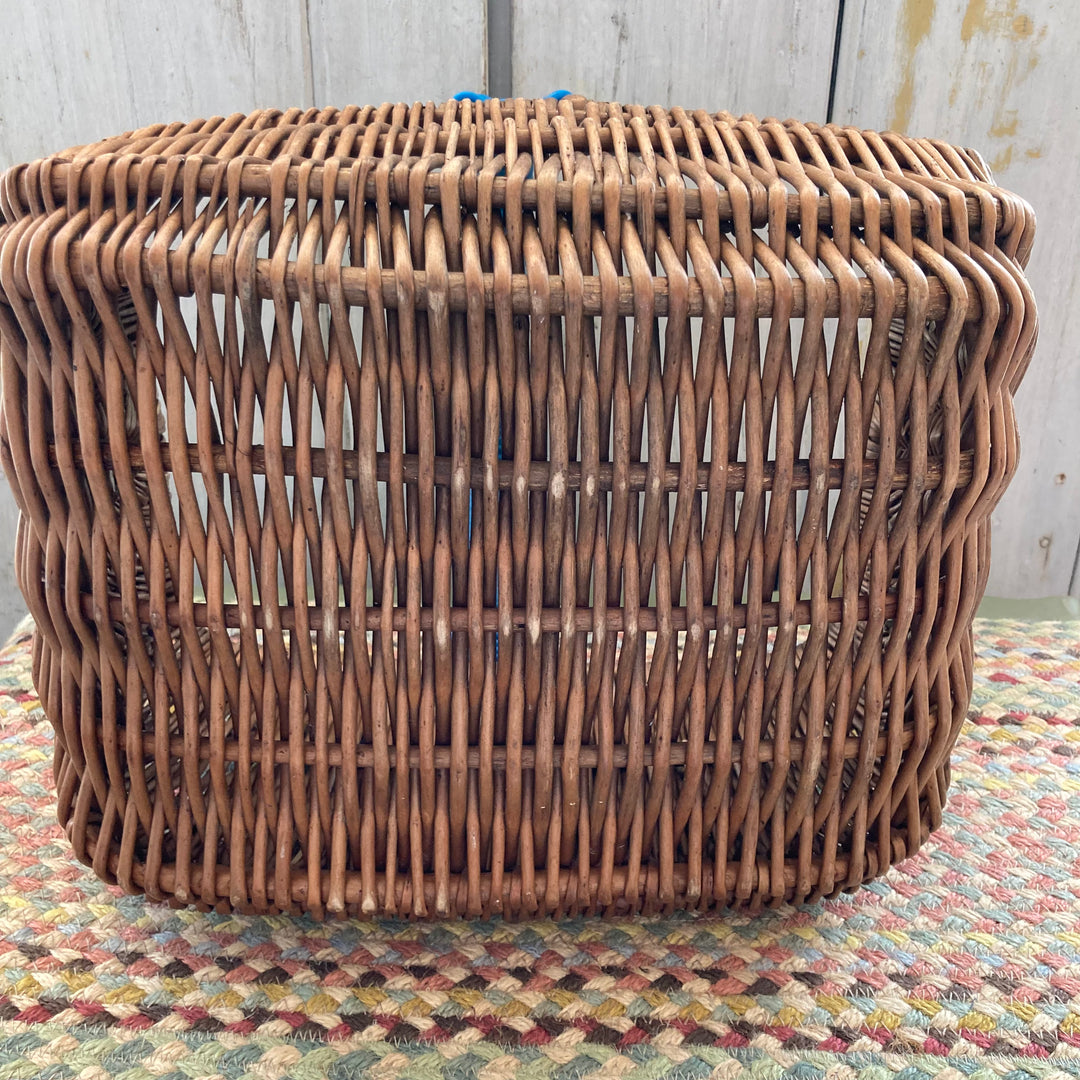 bottom of woven wicker basket with plastic blue handle