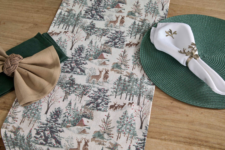 Winter Scene Table Runner - Longer Length displayed with green napkins and decorative plates on a wooden table.