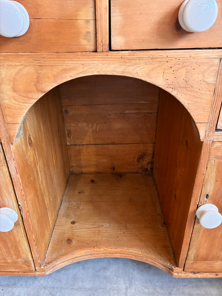 Interior view of the Small Antique Pine Kneehole Desk showing the arched kneehole and wooden finish, crafted by Source for the Goose.
