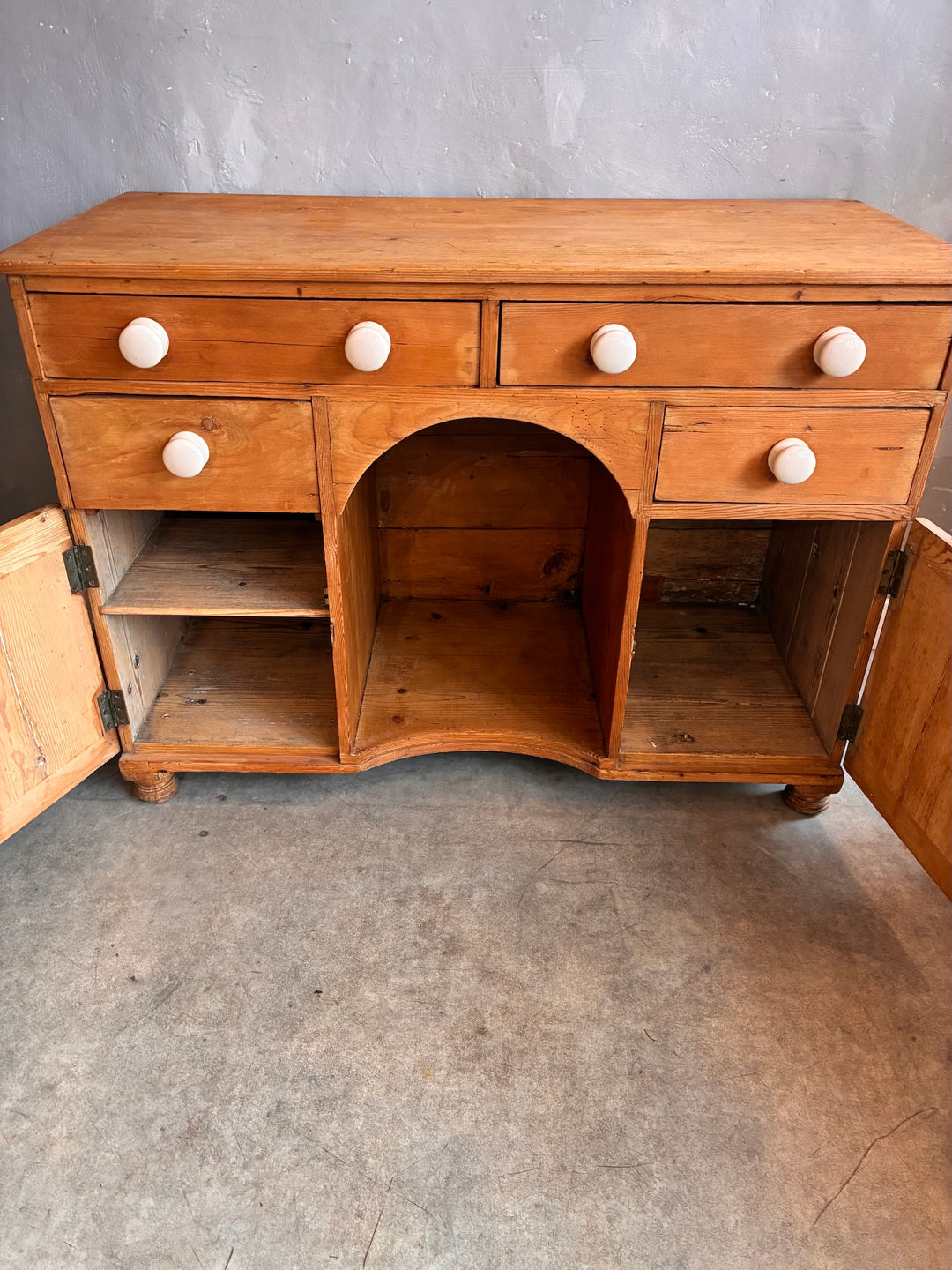 Small Antique Pine Kneehole Desk featuring drawers and cupboards, crafted from solid wood with white porcelain knobs.