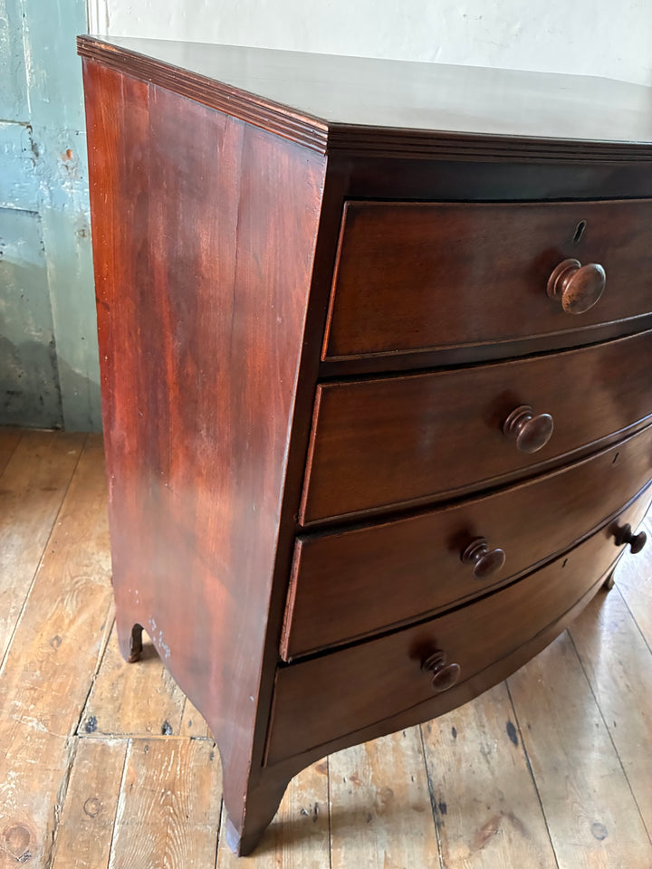 Antique Mahogany Bow Front Chest of Drawers showcasing elegant bow-front styling and original wooden knobs in a vintage home setting.