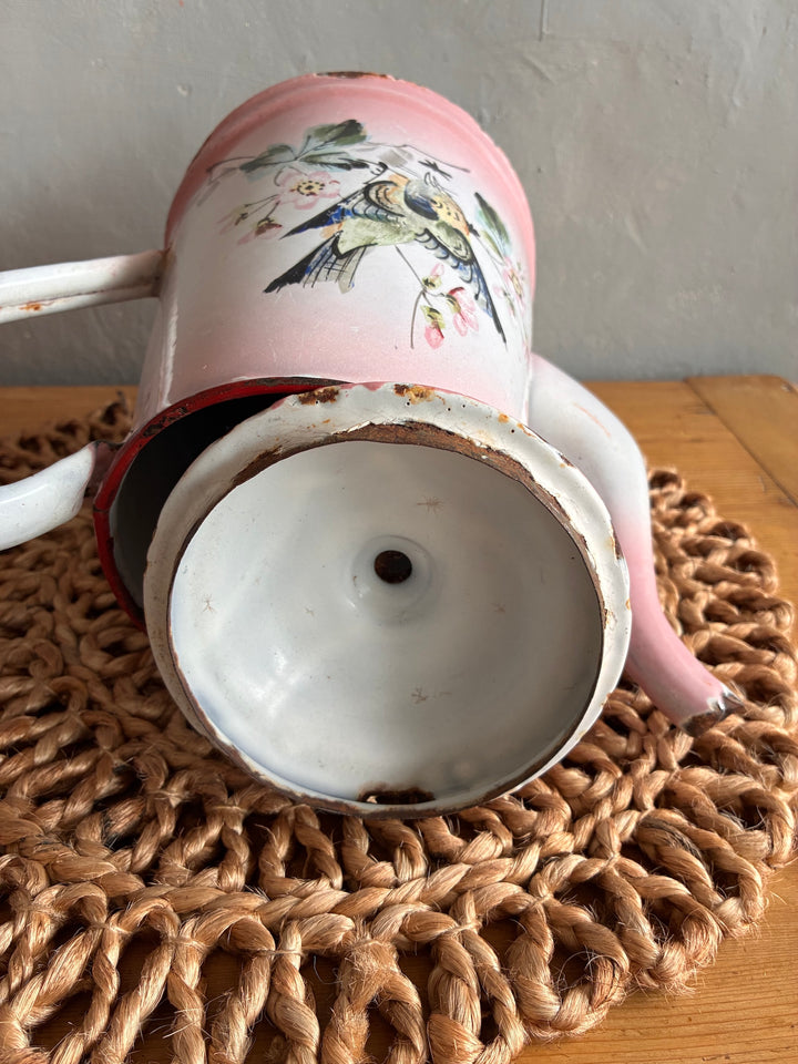 Vintage pink and white French enamel coffee pot showing hand-painted bird design and charming distressed finish.