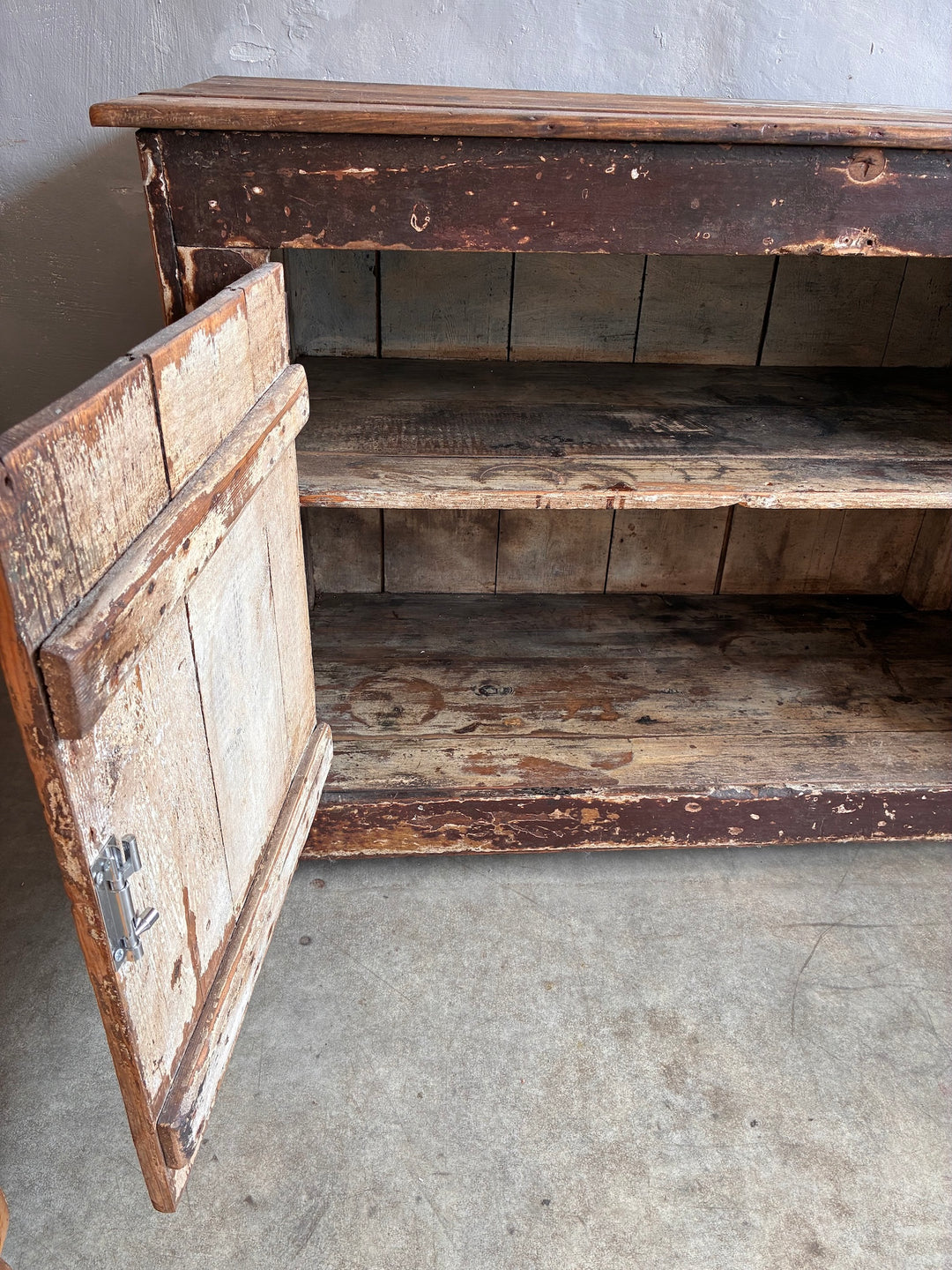 Primitive Antique Pine Wooden Sideboard showcasing an authentic distressed finish with an open door revealing storage space.