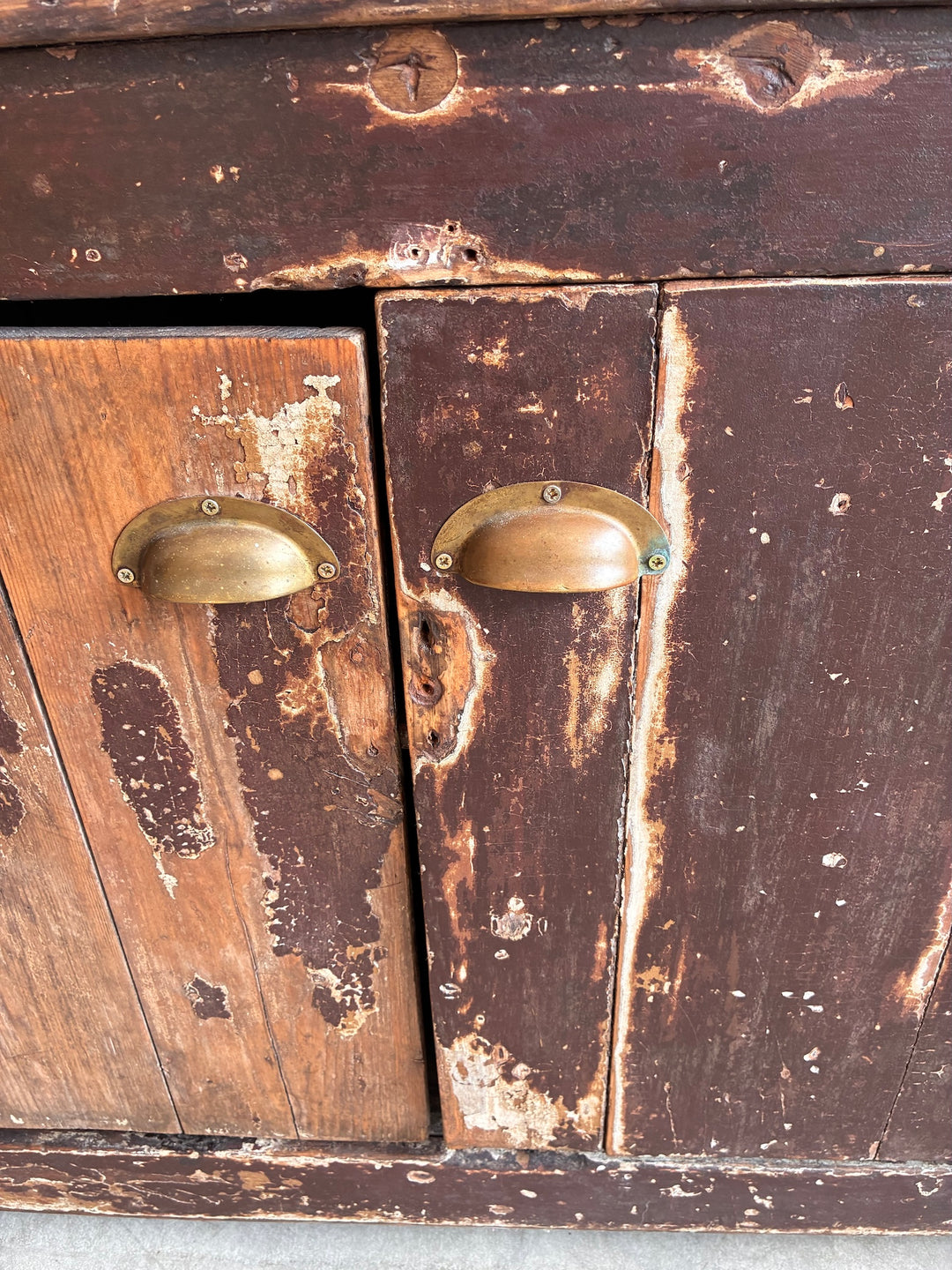Close-up of the distressed finish and brass handles on a Primitive Antique Pine Wooden Sideboard.