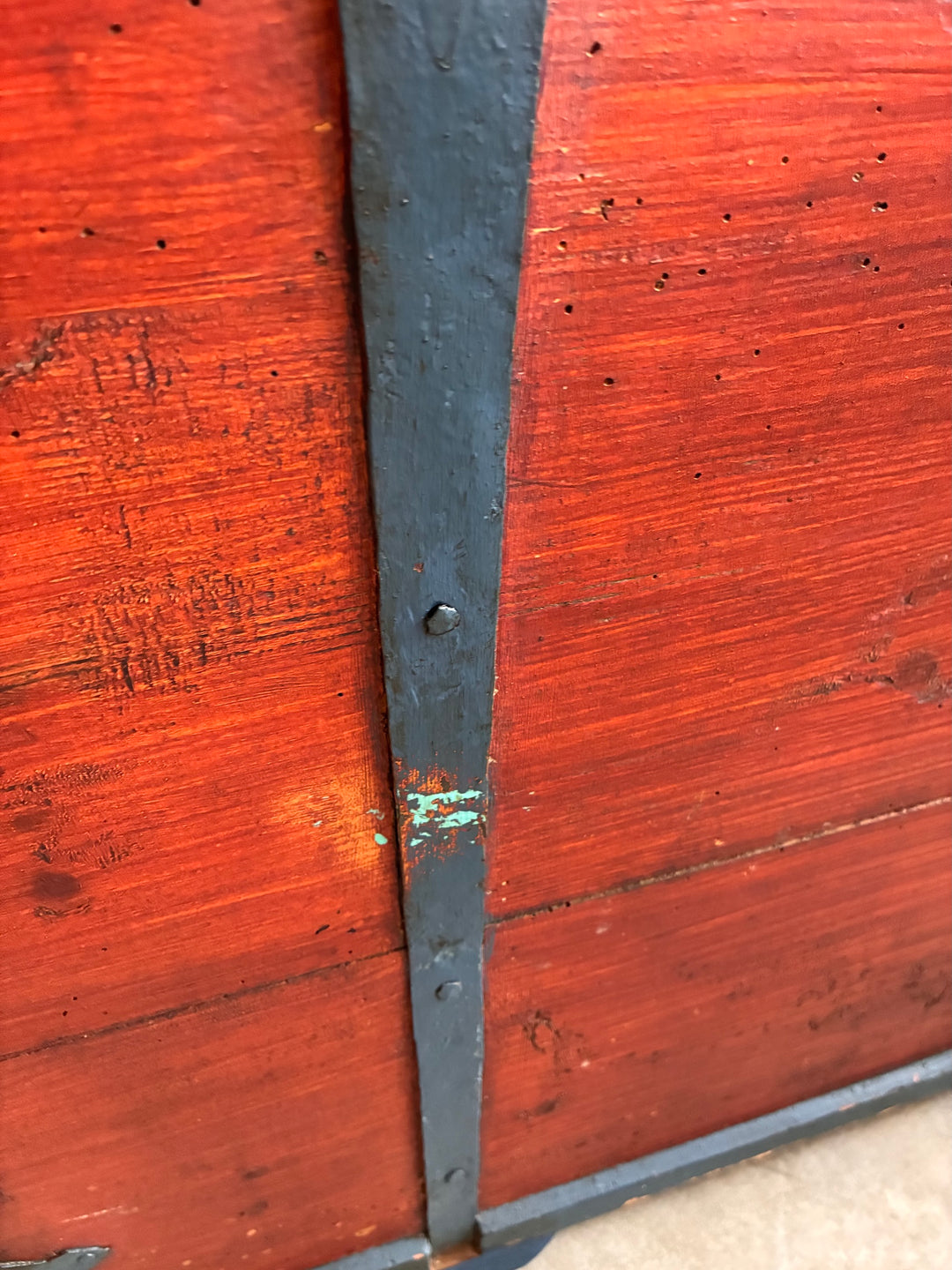 Close-up of Antique Danish Dowry Chest showing blue iron hinges and painted wooden surface details.