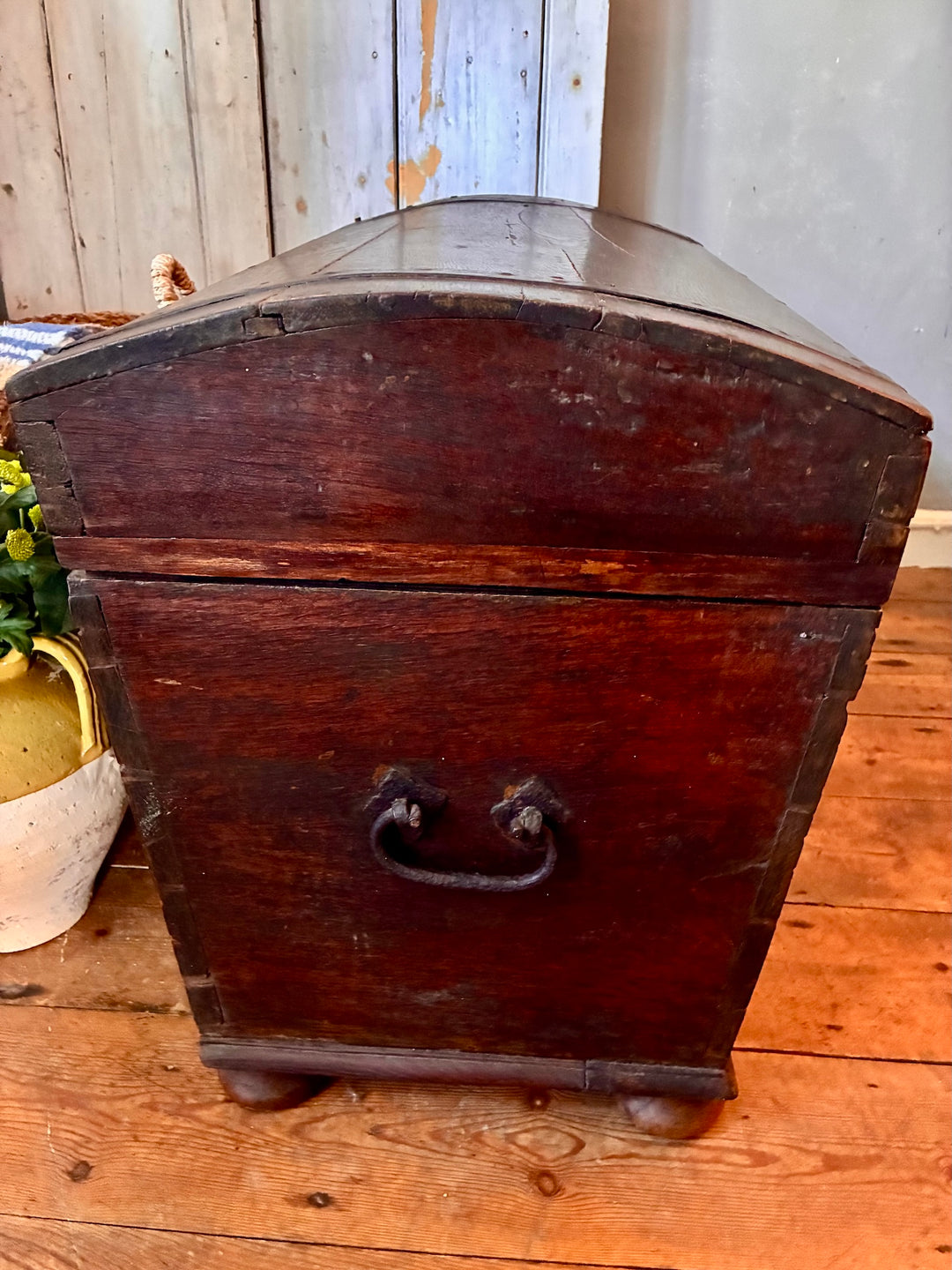 Antique Wooden Dome Top Trunk showcasing rustic charm with stained pine, metal banding, and iron handles.
