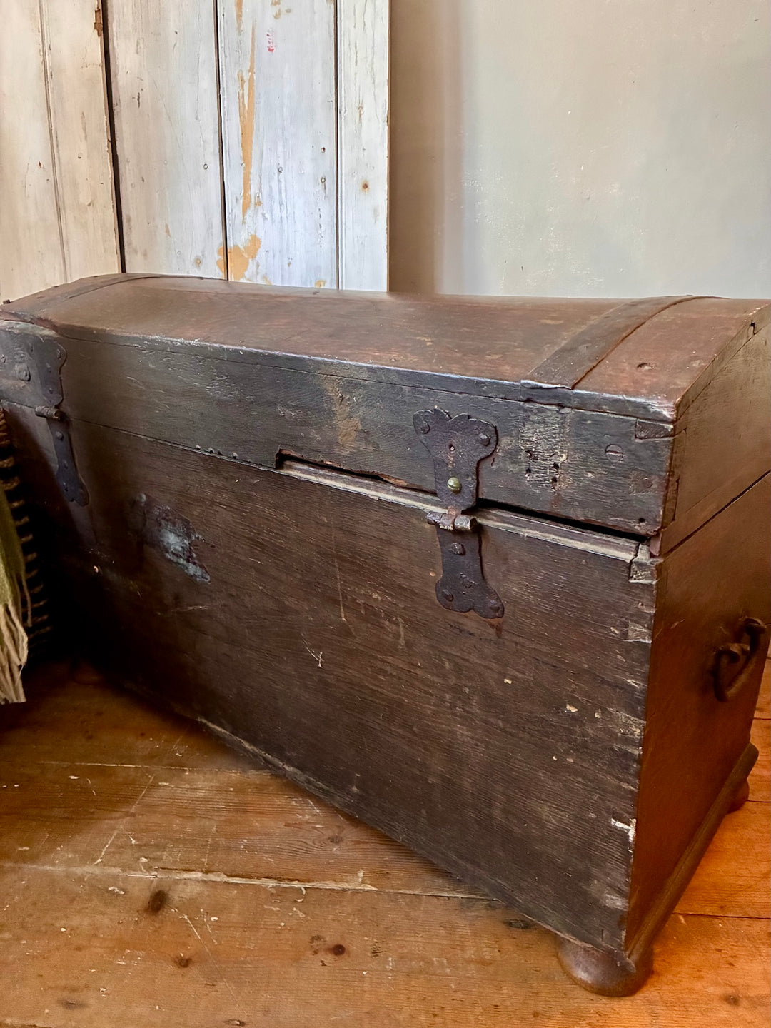 Antique Wooden Dome Top Trunk with metal banding and handles, capturing rustic charm of vintage travel pieces.