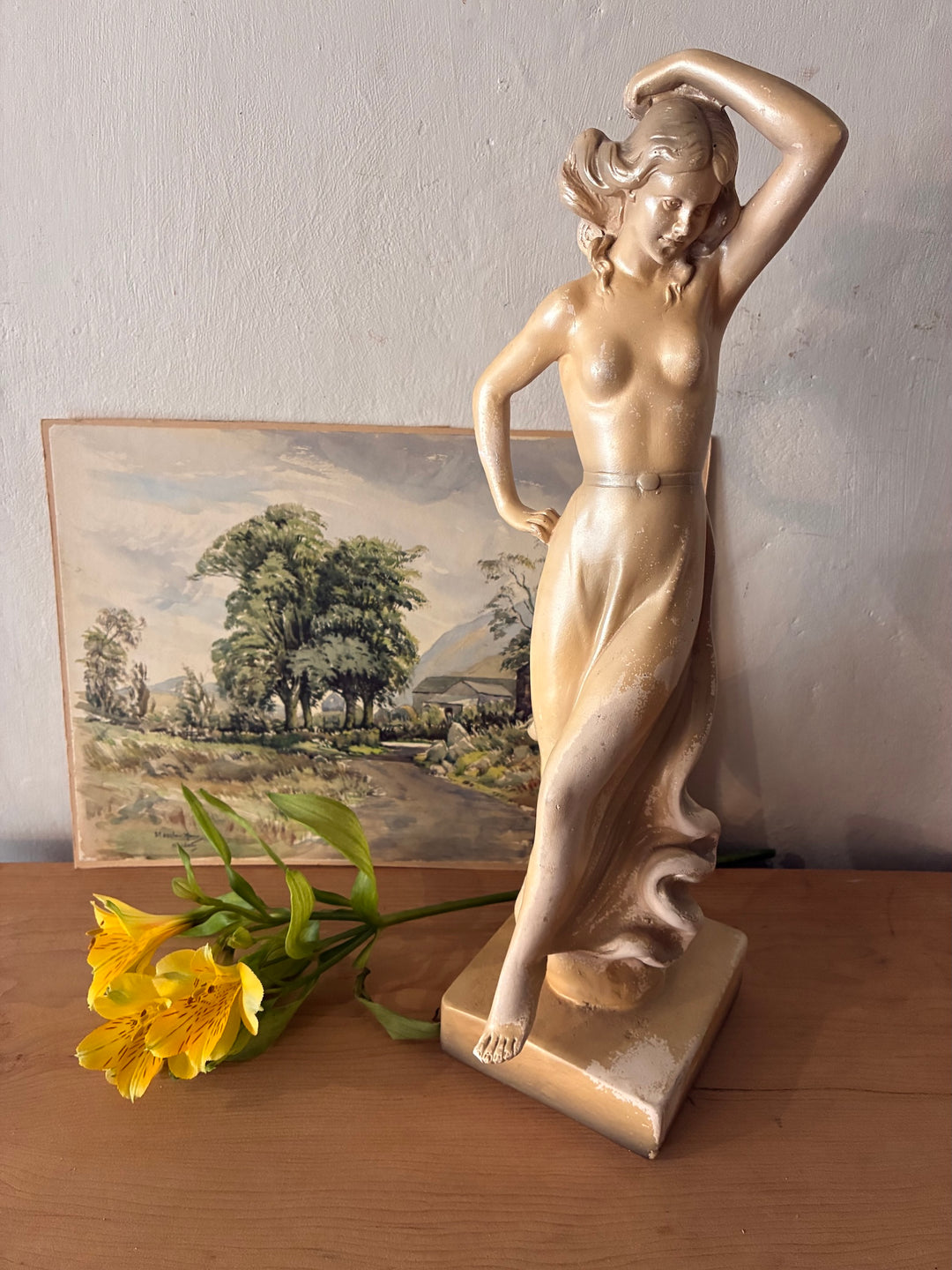 Antique Art Deco Chalkware Lady Figurine showcasing vintage elegance with a decorative flower on a wooden surface.