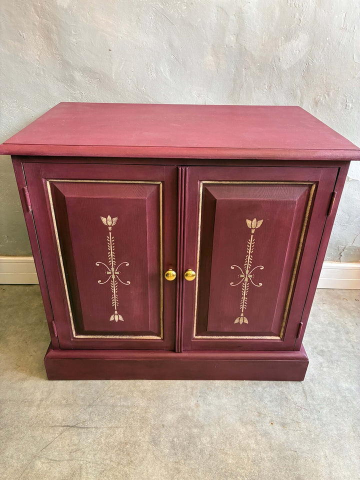 Aubergine folk art style cupboard with hand-painted details, perfect for small spaces, from Source for the Goose, Devon.