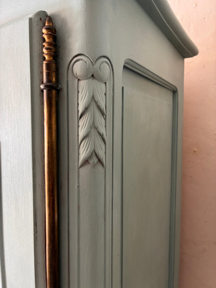 Detail of Small Blue Painted French Armoire showcasing carved leaf design and golden accent handle.