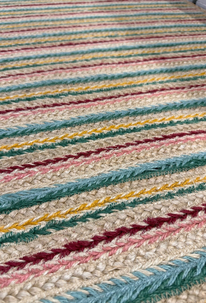 Ikat Stripe Organic Jute Braided Rug close-up, showcasing colorful jute runner design with pink, teal, and ochre hues.