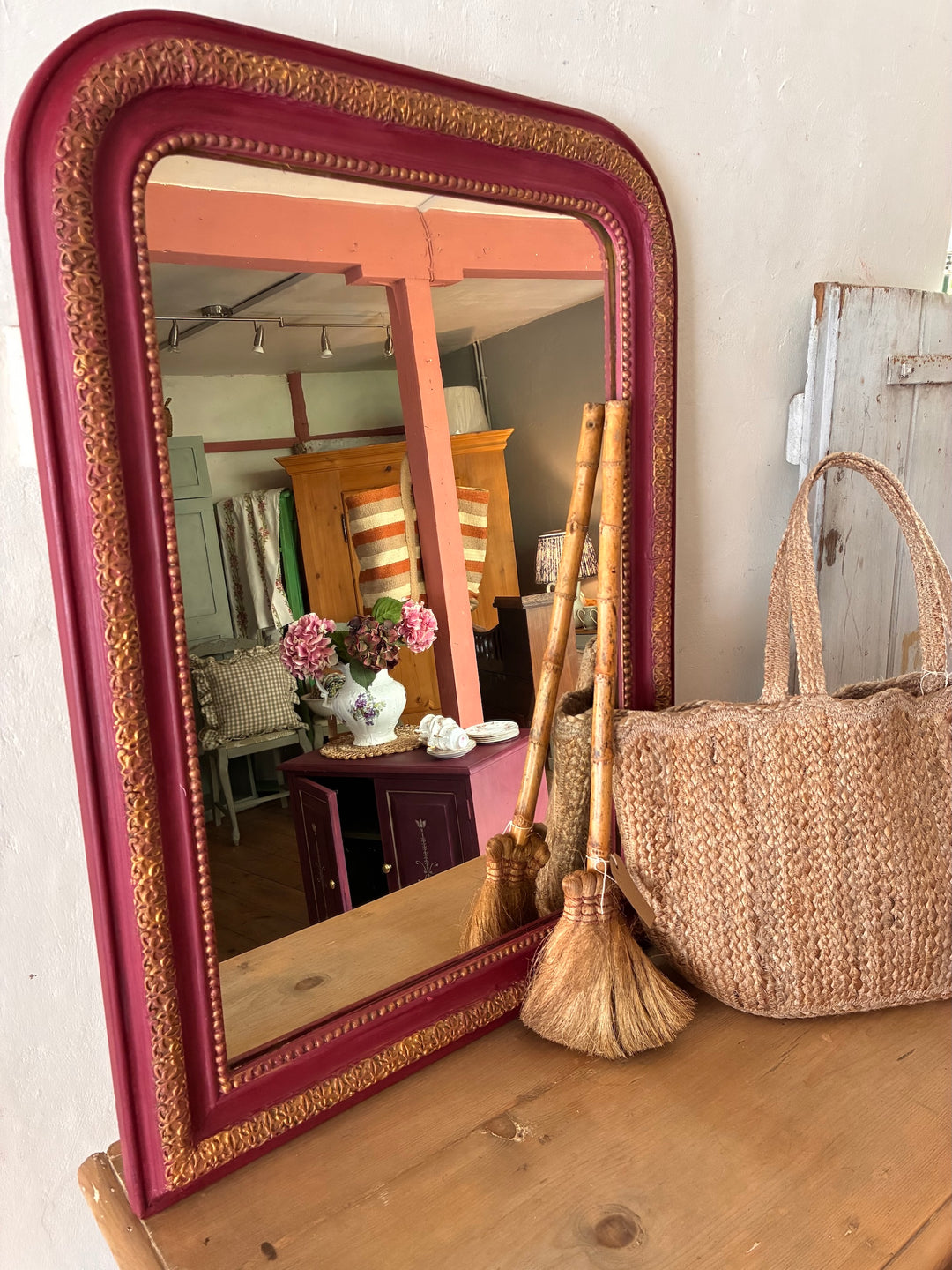 Vintage arch top French mirror with burgundy frame and gold trim, styled with decorative items, Source for the Goose, Devon.