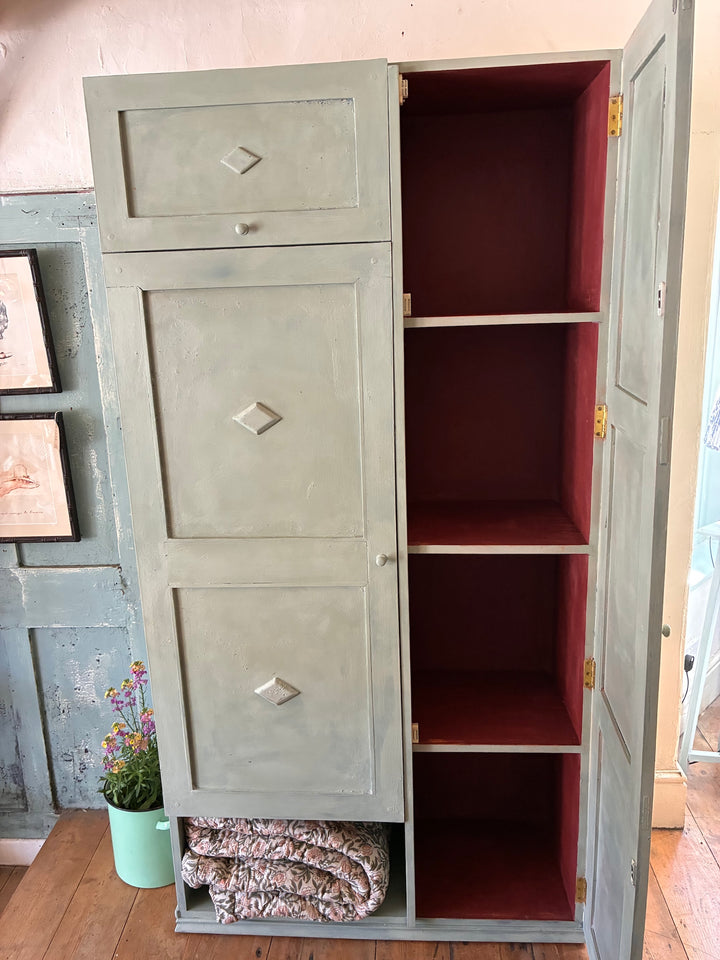 Tall vintage green wooden cupboard with distressed red interior and storage options, sourced from Source for the Goose, Devon.