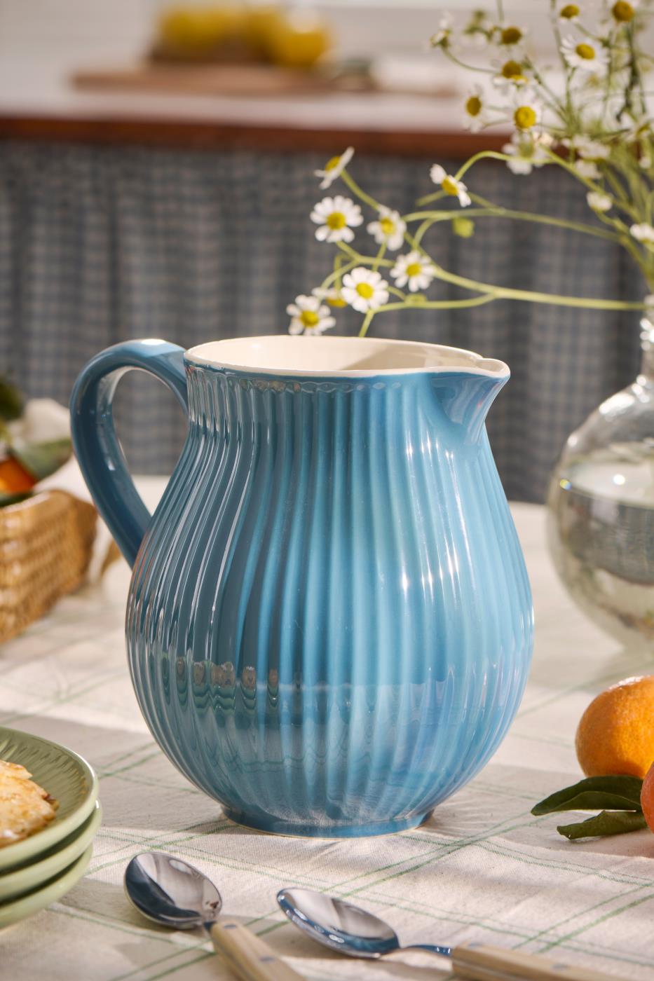 Cornflower Blue Pitcher Jug - Ribbed Design on a table with flowers, perfect for adding charm to any setting.