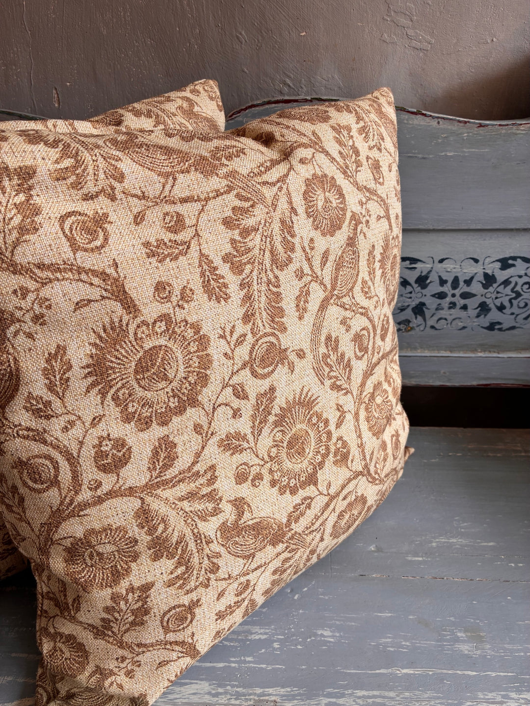 Decorative pillow with floral pattern on a wooden surface