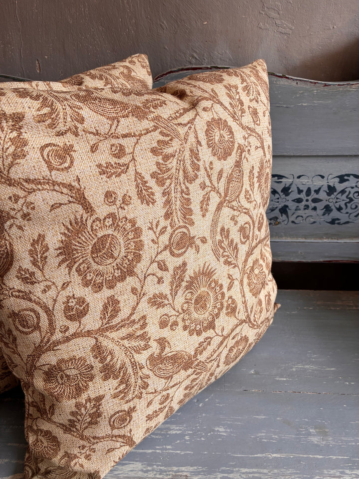 Decorative pillow with floral pattern on a wooden surface