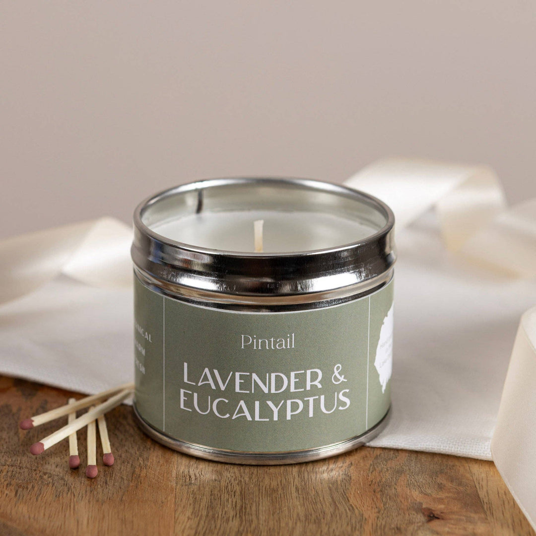 Pintail Candles - Lavender & Eucalyptus Classic Tin on a wooden surface with matches beside it.