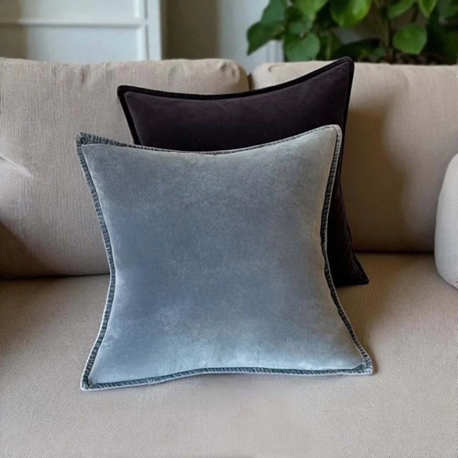 Stonewashed velvet cushions in grey and dark shades on a cozy sofa from Source for the Goose, Devon.