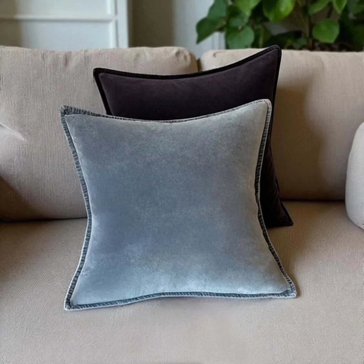 Stonewashed velvet cushions in grey and dark shades on a cozy sofa from Source for the Goose, Devon.
