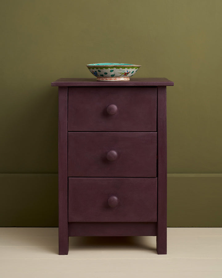 Tyrian Plum Chalk Paint® applied on a three-drawer bedside cabinet with a decorative bowl on top, by Source for the Goose Devon.