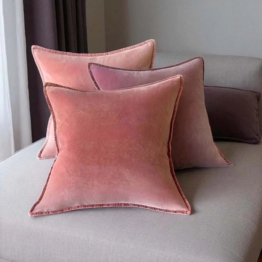 Stonewashed velvet cushions in dusky pink and soft purple on a sofa, perfect for cozy home decor from Source for the Goose.
