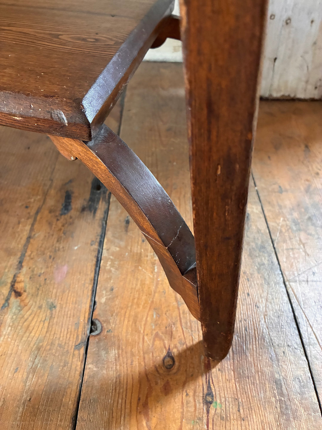 Side view of an Edwardian writing desk showing detailed leg design and wooden texture. Source for the Goose, Devon.