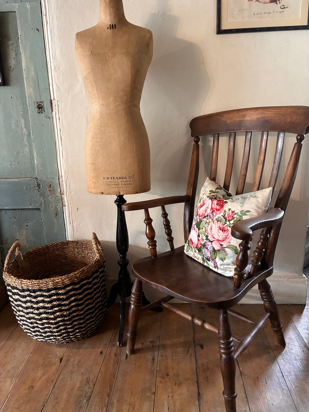 Victorian Windsor Lathe Back Chair with floral cushion beside a dress form and woven basket in rustic interior decor.