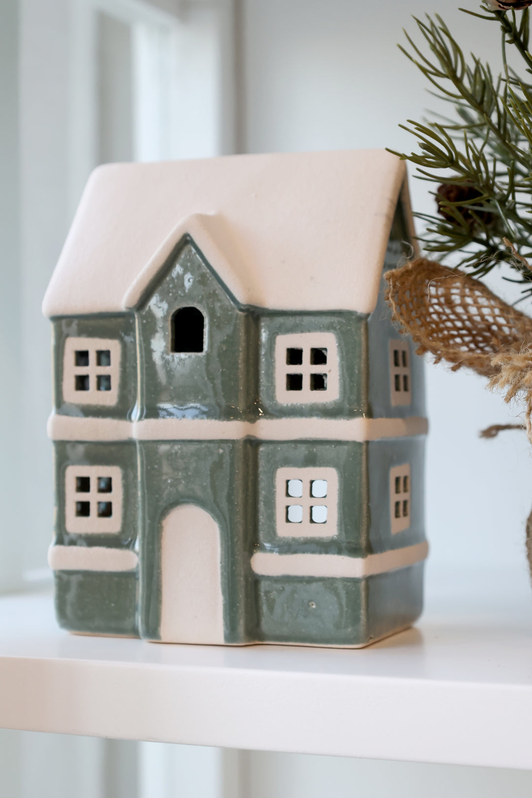 Green ceramic house tealight holder with snowy roof, adding vintage charm to home decor from Source for the Goose, Devon.