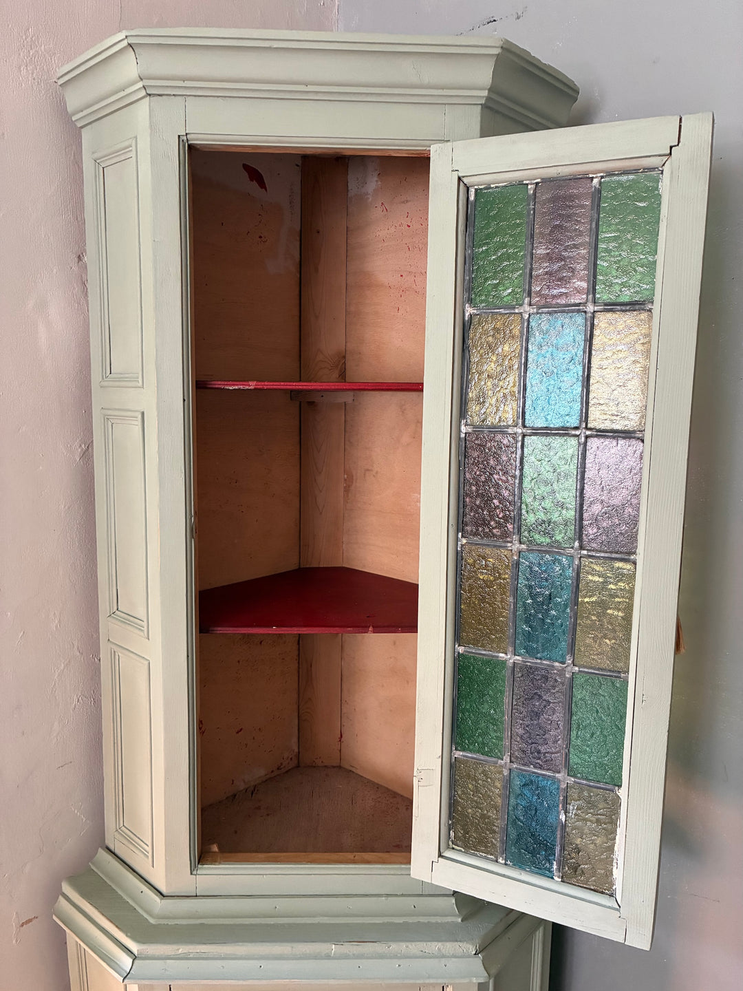 Green Painted Corner Cupboard with Stained Glass Panel showcasing shelves and vintage detailing.