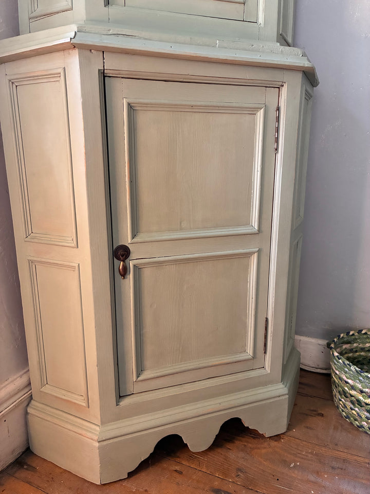 Green Painted Corner Cupboard with Stained Glass Panel showcasing vintage details and charm in a cottage core setting.