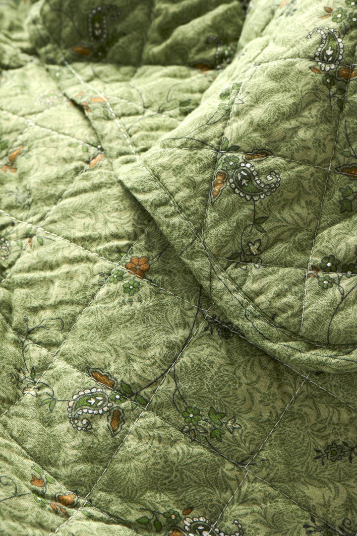 Soft Green Quilted Throw with floral and paisley patterns, perfect for adding warmth and style to your home decor.