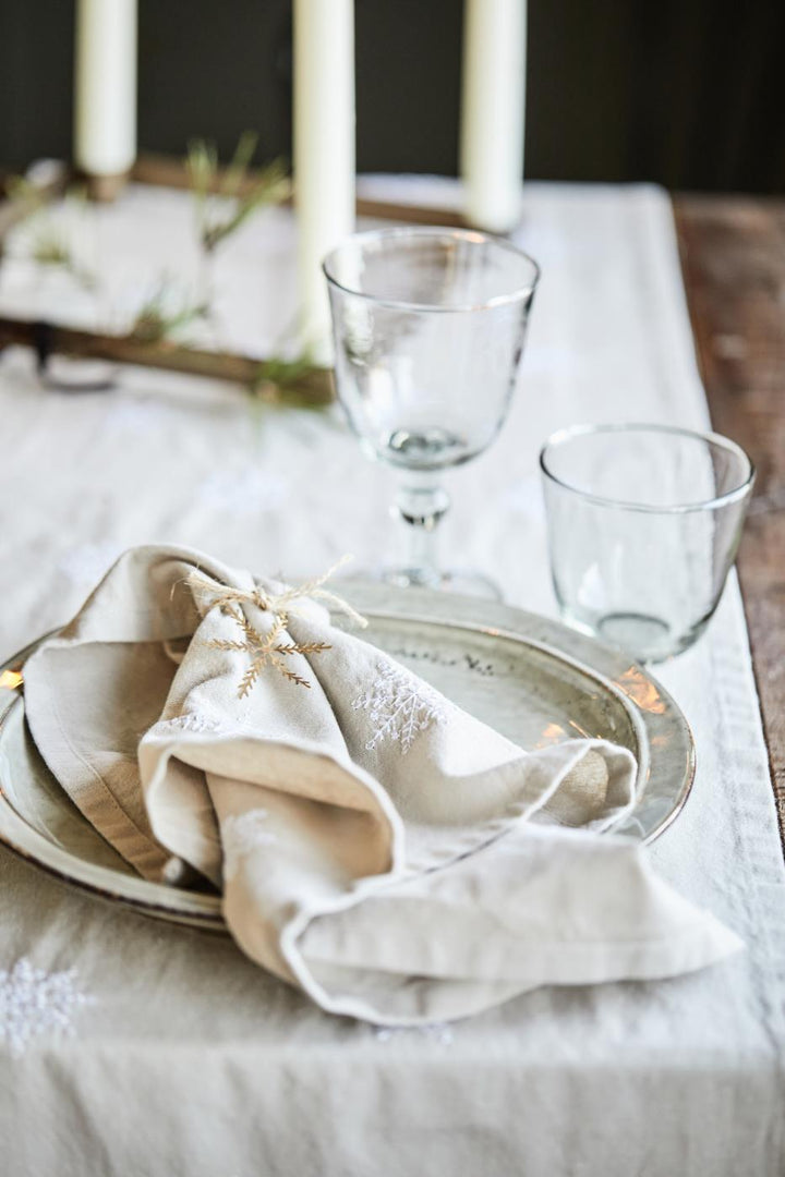 rustic winter table setting with linen coloured runner and napkins with snowflakes