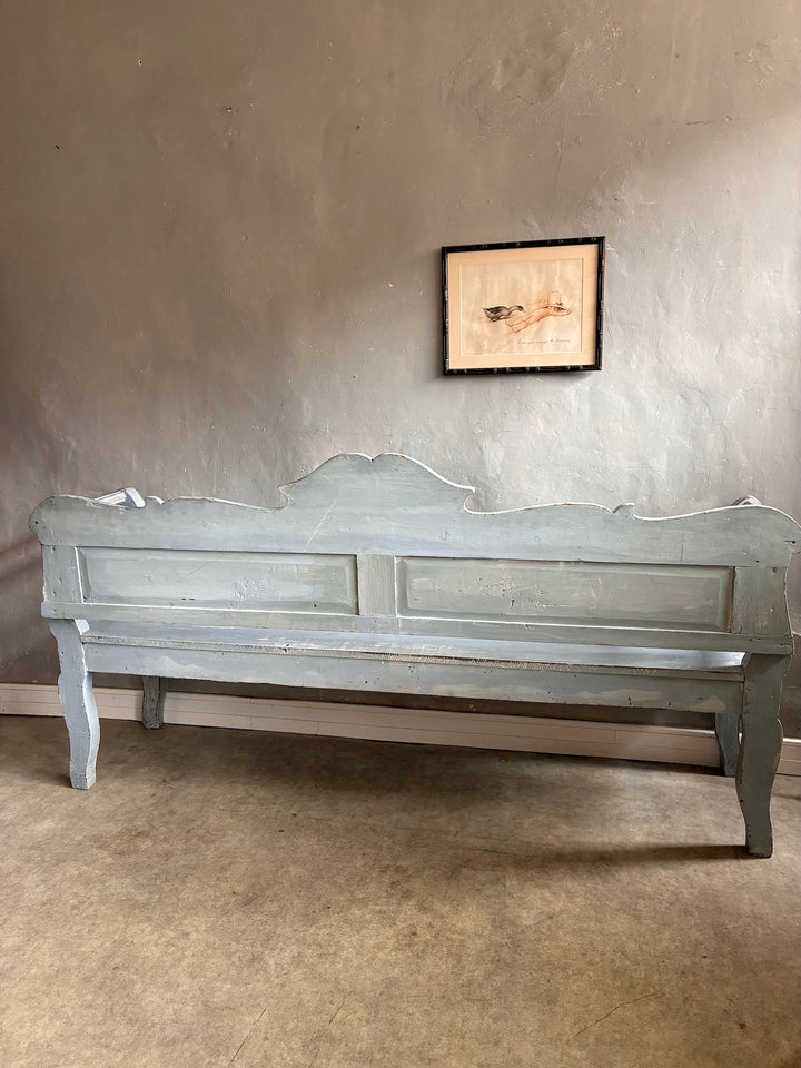 Vintage Long Painted Hungarian Bench displayed against a textured wall, featuring timeworn blue paint and charming distressed finishes.