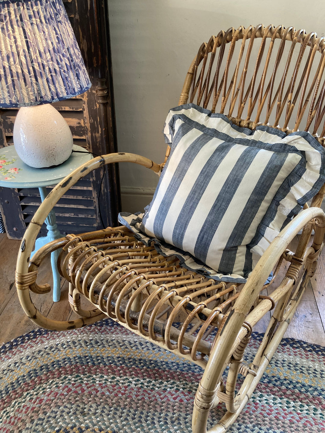 Low Retro Wicker Rocking Chair with a plump blue stripe ruffled cushion for sale at Source for the Goose, Devon