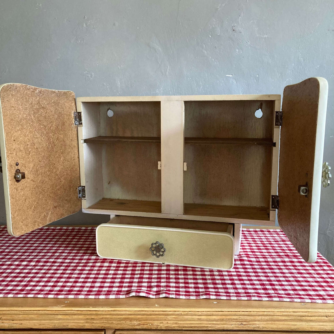 Mid Century French Wall Cabinet with doors open, showcasing ample storage space, filigree handles, and a small drawer. Source for the Goose Devon.