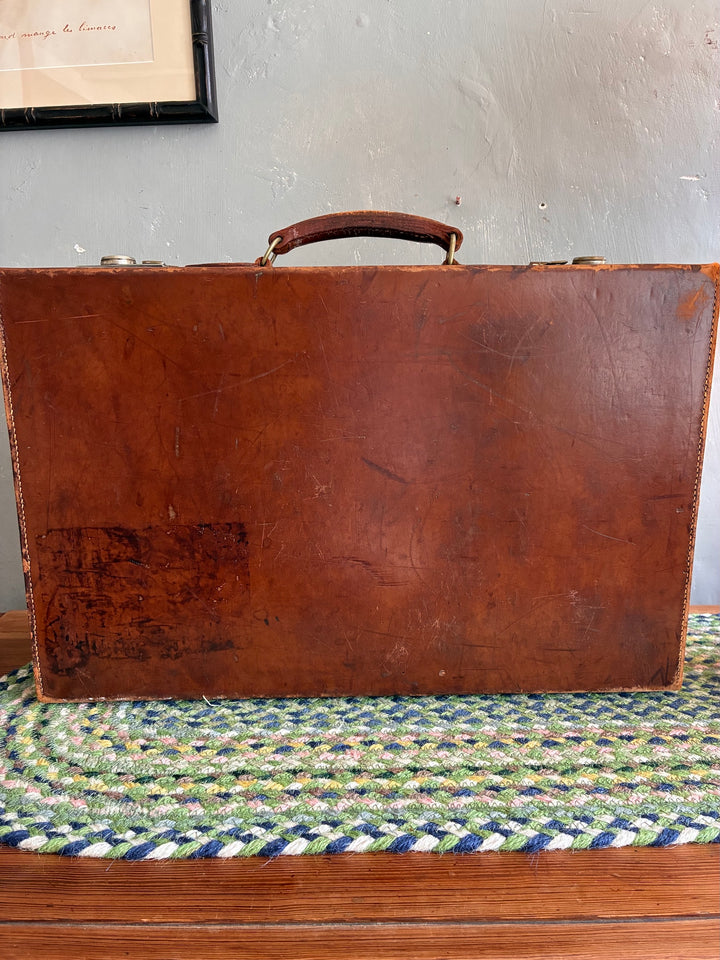 Vintage leather suitcase back view, showcasing rich patina and sturdy construction from Source for the Goose, Devon.