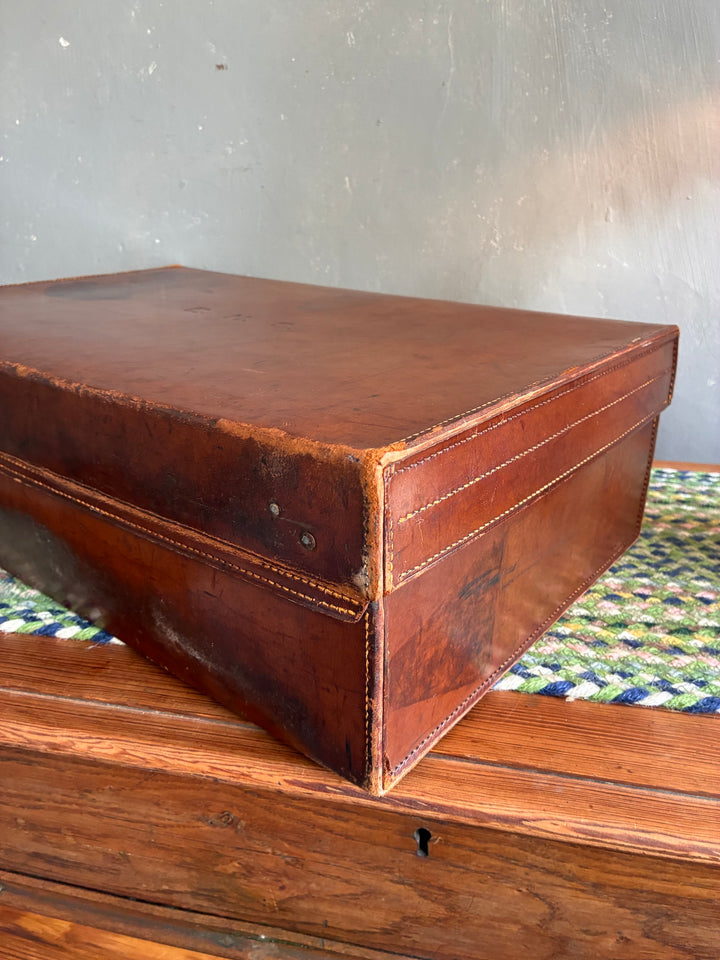 Vintage leather suitcase with initials EHS, featuring a rich patina and sturdy design, from Source for the Goose, Devon.