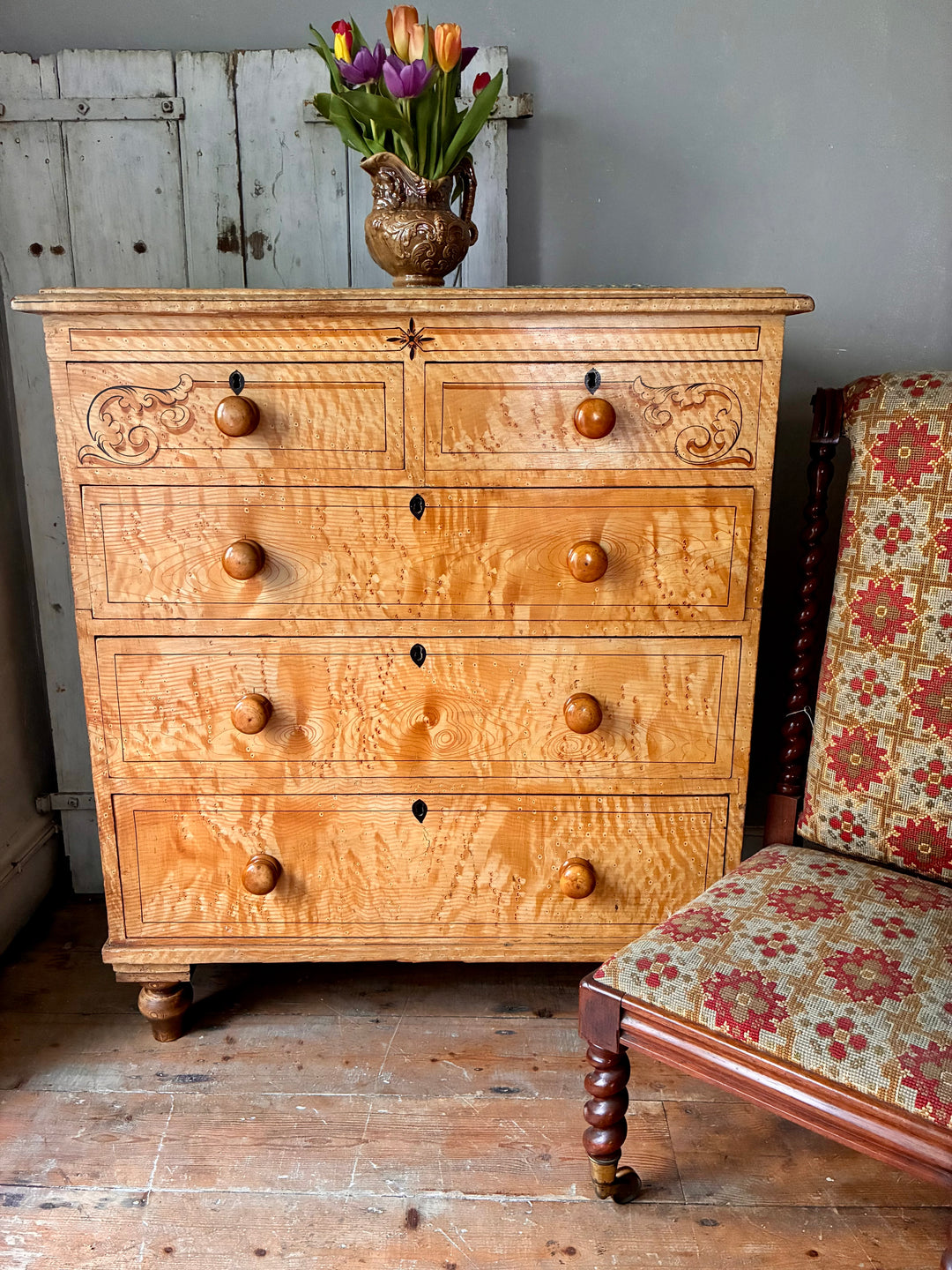 19th Century Scumbled Pine Chest of Drawers with decorative details and flower vase on top.