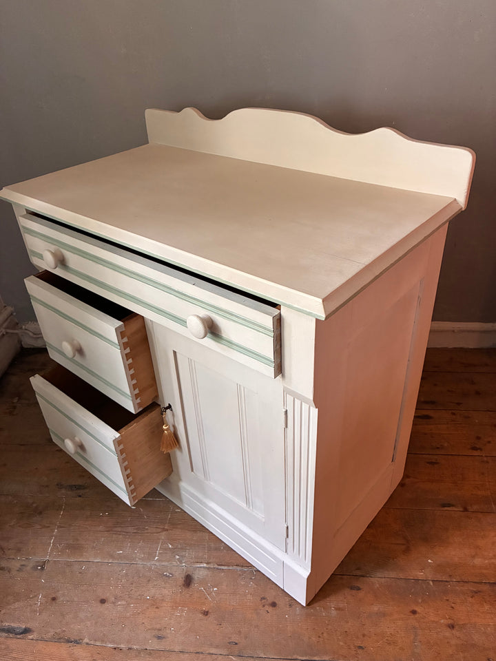 Painted Washstand Cupboard with Drawers featuring soft putty paint and striped detailing, from Source for the Goose Devon.