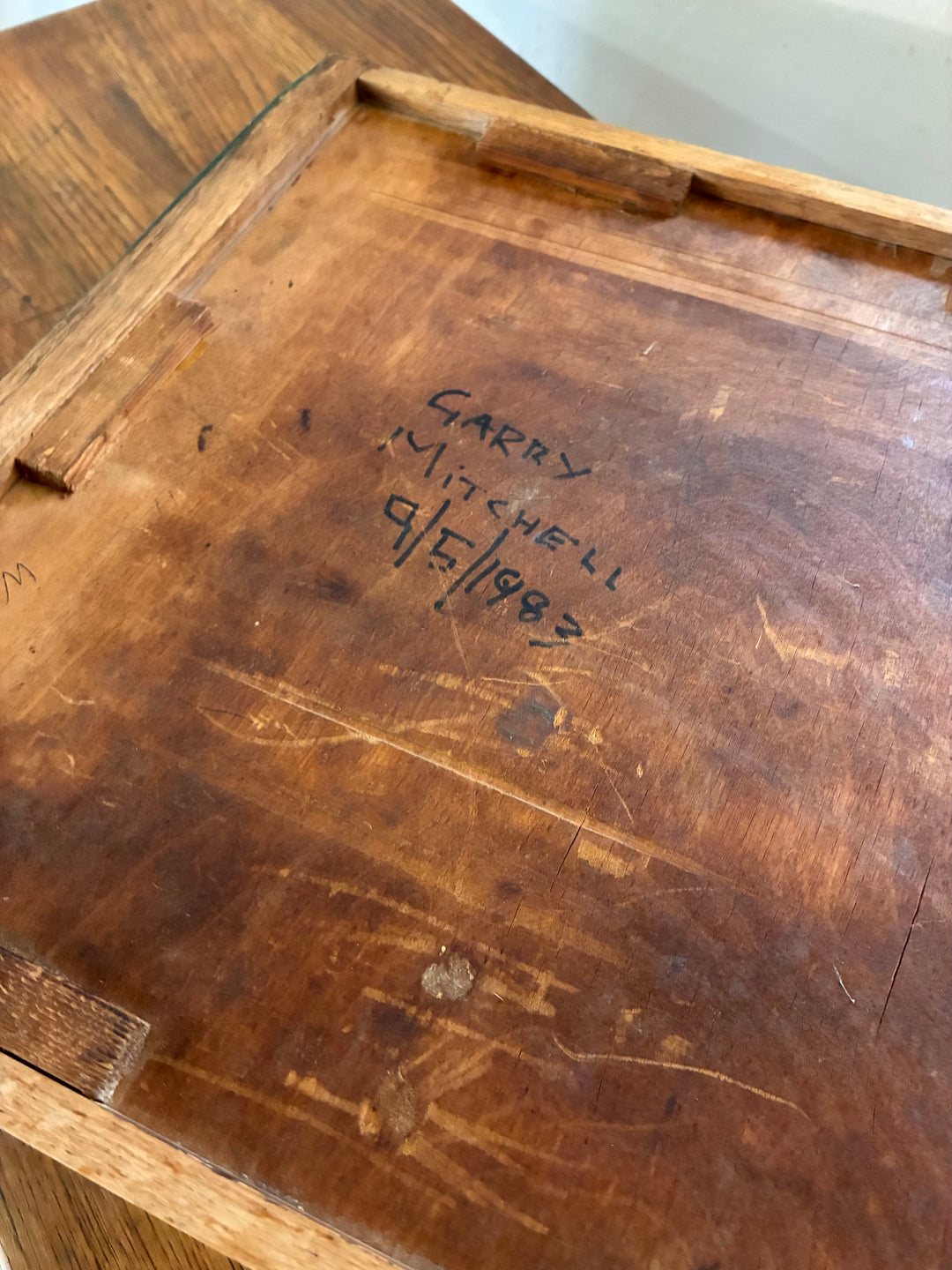 Garry Mitchell's signature and date on vintage wooden furniture piece, showcasing craftsmanship and authenticity.