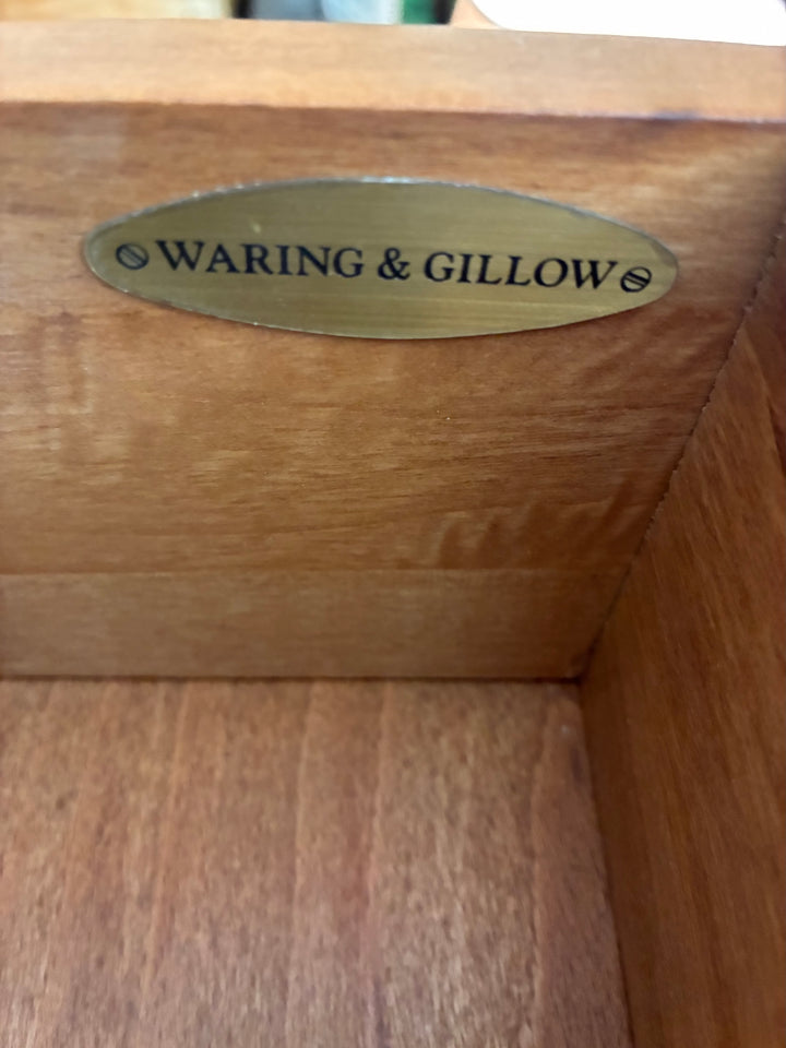 Waring & Gillow brass plaque inside wooden cabinet, highlighting craftsmanship and heritage.