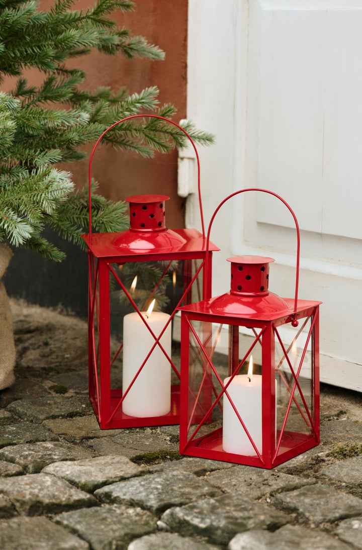 Cheerful red metal lanterns with chimney, glowing candles inside, ideal for cozy autumn decor from Source for the Goose, Devon.