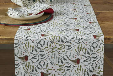 Festive Robin and Mistletoe Table Runner with tassels by Source for the Goose Devon, enhancing Christmas decor on wooden table.