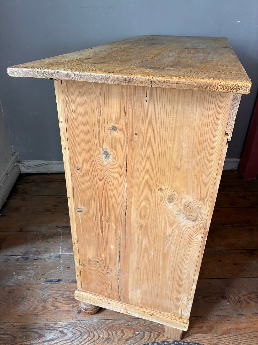 Side view of a Rustic Antique Pine French Cupboard featuring a natural wood finish, showcasing its aged texture and character.