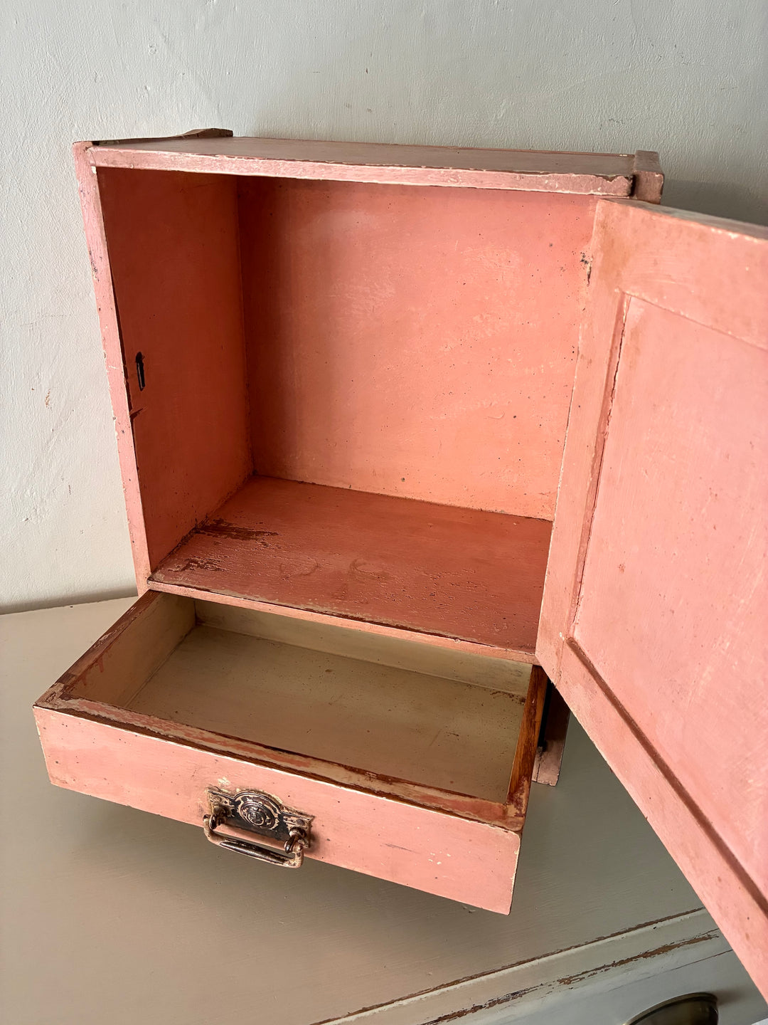 Interior view of Small Vintage Salmon Pink Wall Cupboard by Source for the Goose, featuring a drawer and distressed finish.
