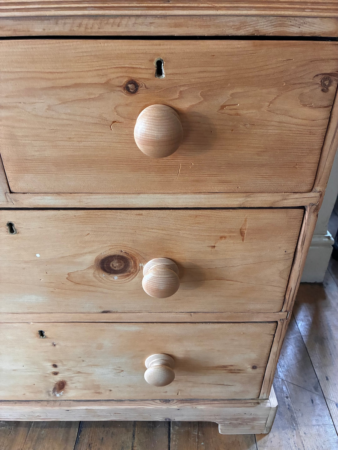 Close-up of Small Antique Victorian Pine Chest of Drawers showing wooden knobs and rustic charm.