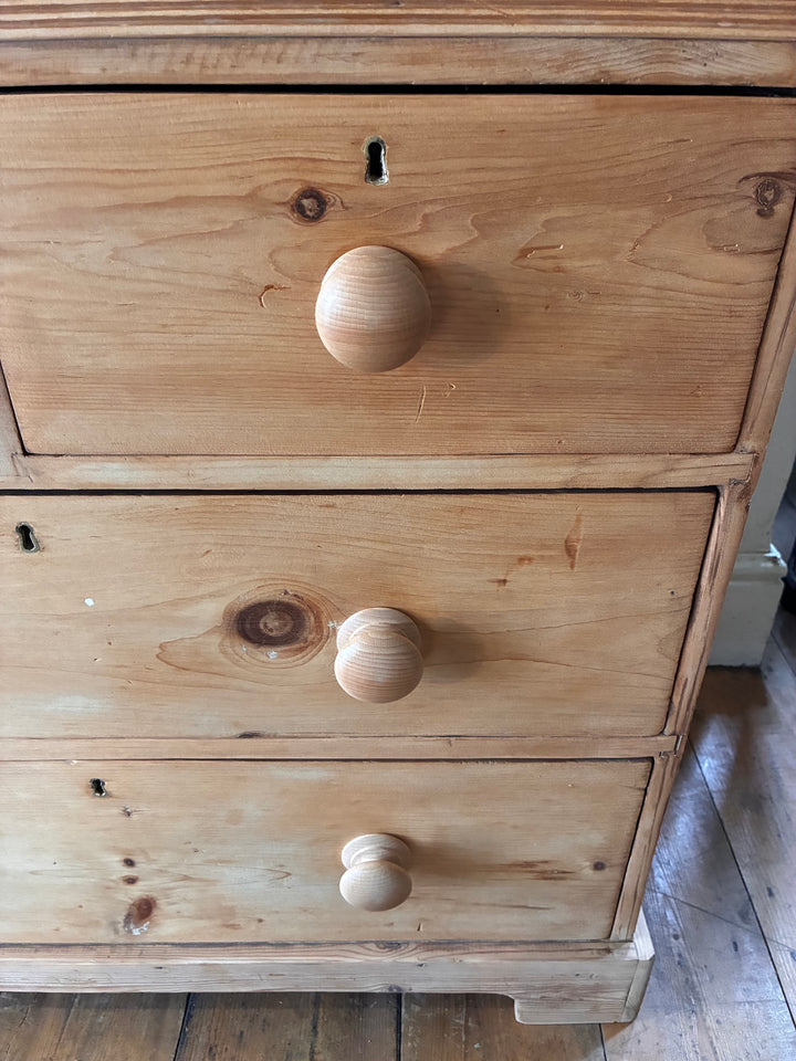 Close-up of Small Antique Victorian Pine Chest of Drawers showing wooden knobs and rustic charm.