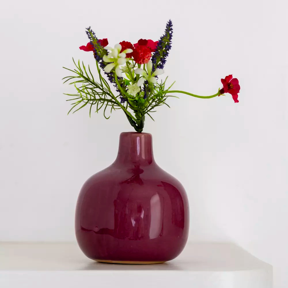 Dainty ceramic bud vase in vibrant berry pink with fresh flowers on a shelf, Source for the Goose, Devon.