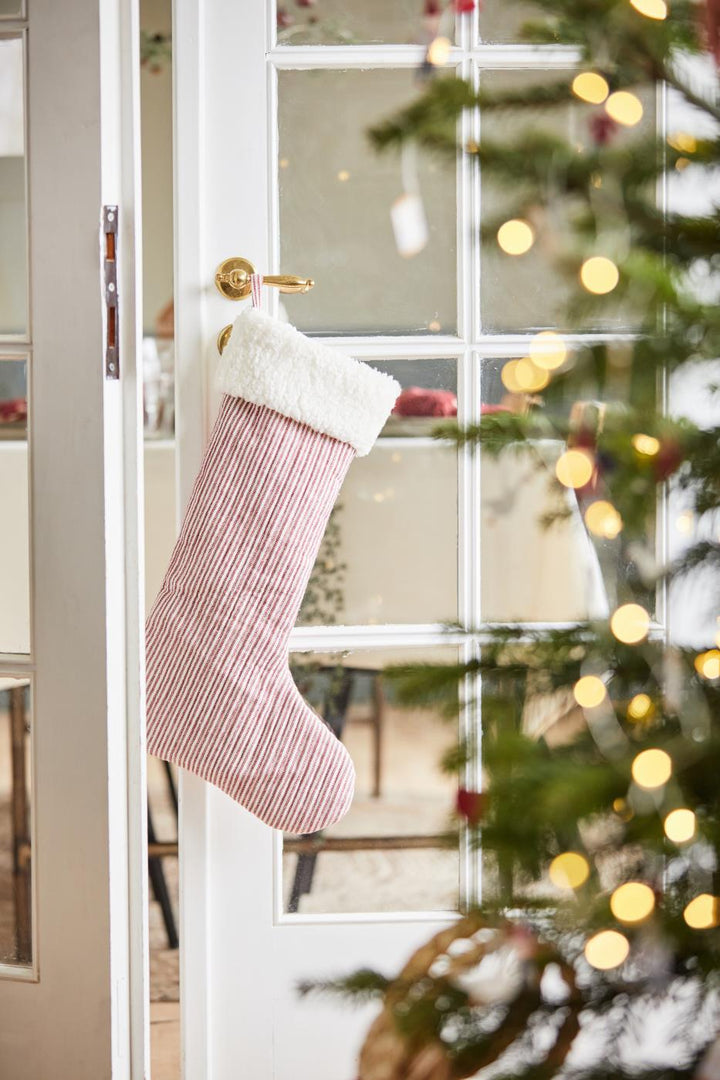 red stripe stocking with fur top hanging from a door handle