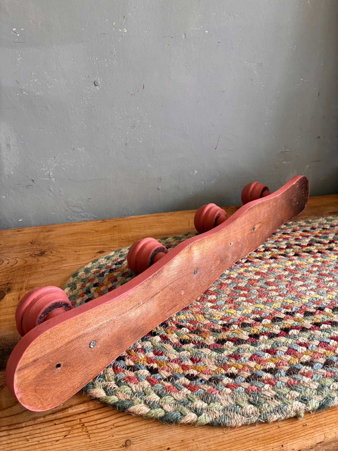 Earthy Pink Vintage French Coat Hooks displayed on a textured rug, showcasing its charming salmon pink finish.